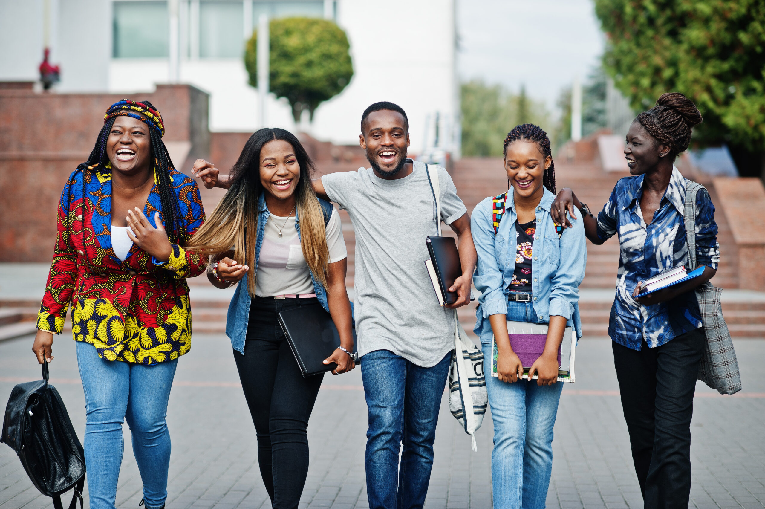 Student smiling broadly on an open university campus grounds